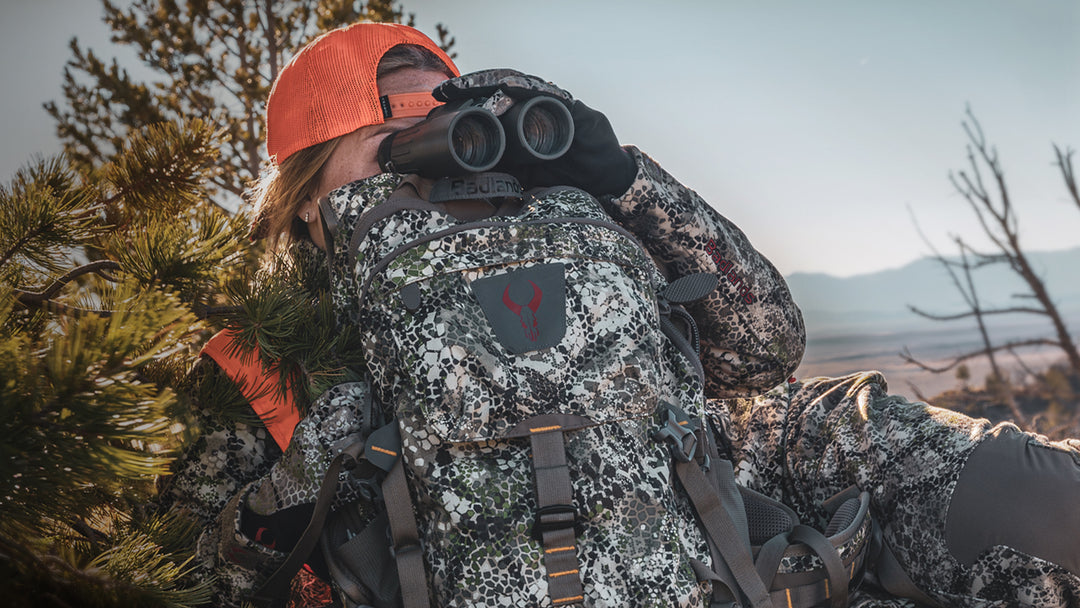 woman looking through binoculars on a hunt