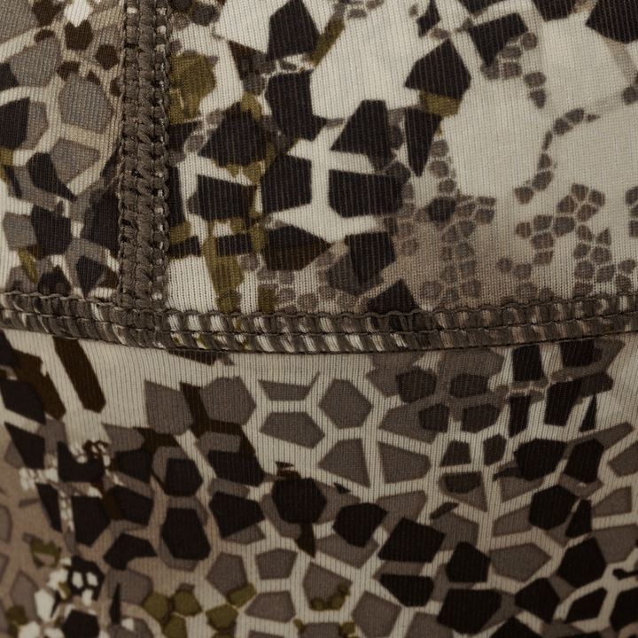 Close-up of Badlands camo fabric with detailed stitching; hexagonal pattern aids concealment for outdoor activities.