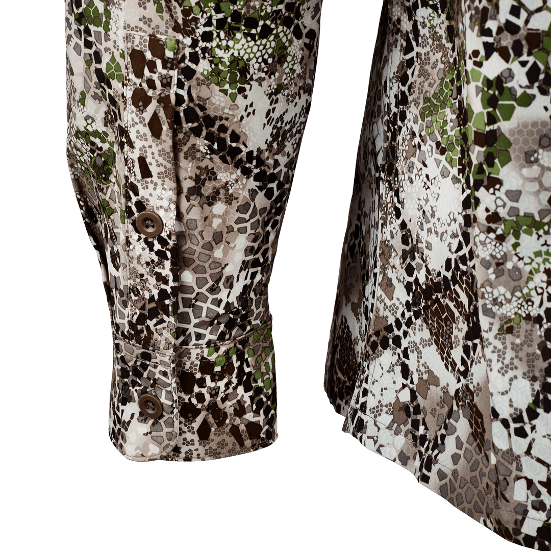 Close-up of Badlands camo shirt sleeves with buttons, featuring the signature skull logo pattern for outdoor use.