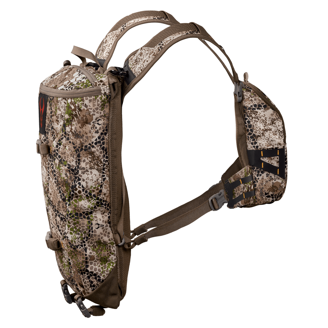 Camo-patterned Badlands hunting pack with red skull logo, ergonomic straps, and compact design for outdoor use.