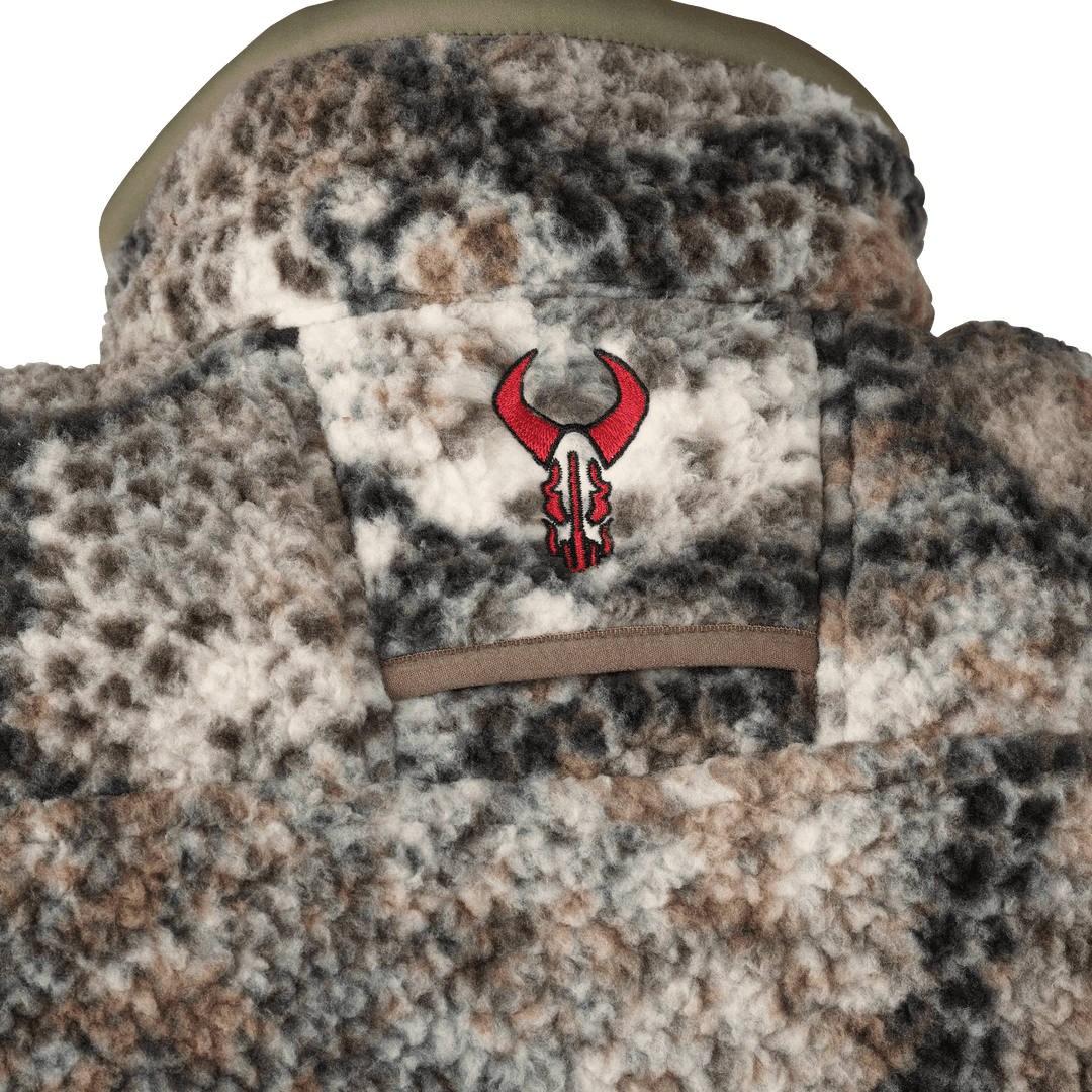 Close-up of a camo fleece jacket with the red Badlands skull logo embroidered on the back collar.