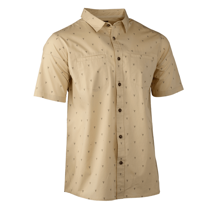 Tan short-sleeve button-up shirt with subtle Badlands skull logo print, two chest pockets, and dark buttons.