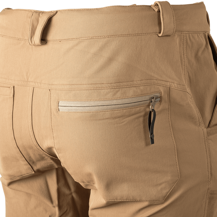 Close-up of tan Badlands pants back pocket with zipper and pull tab, showing durable stitching and accessible storage.