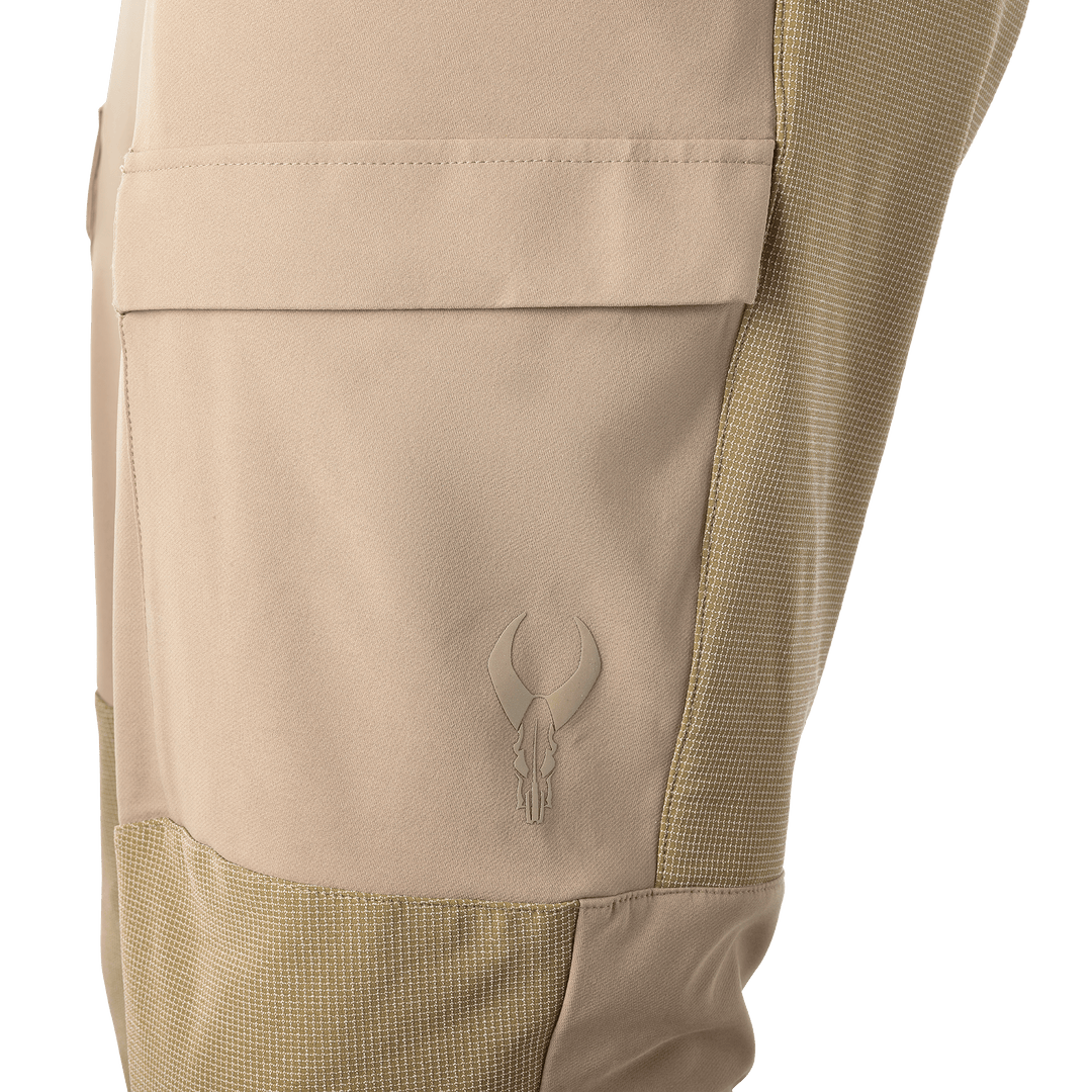 Tan Badlands pants pocket with skull logo; textured side panel for durability and contrast.