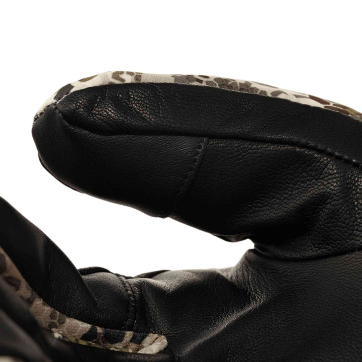 Close-up of a Badlands glove thumb in camo and black leather, showing texture and stitching detail.