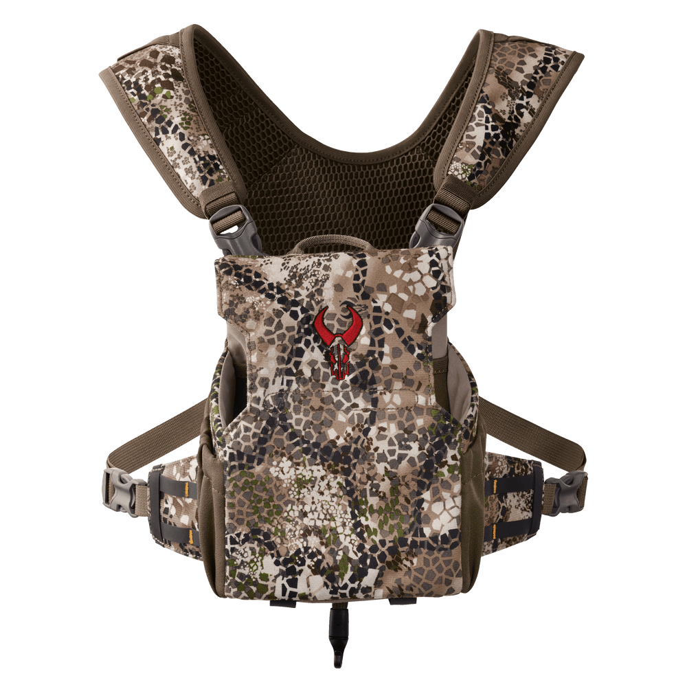 Badlands camo binocular harness with red skull logo, adjustable straps, and mesh backing for outdoor use.