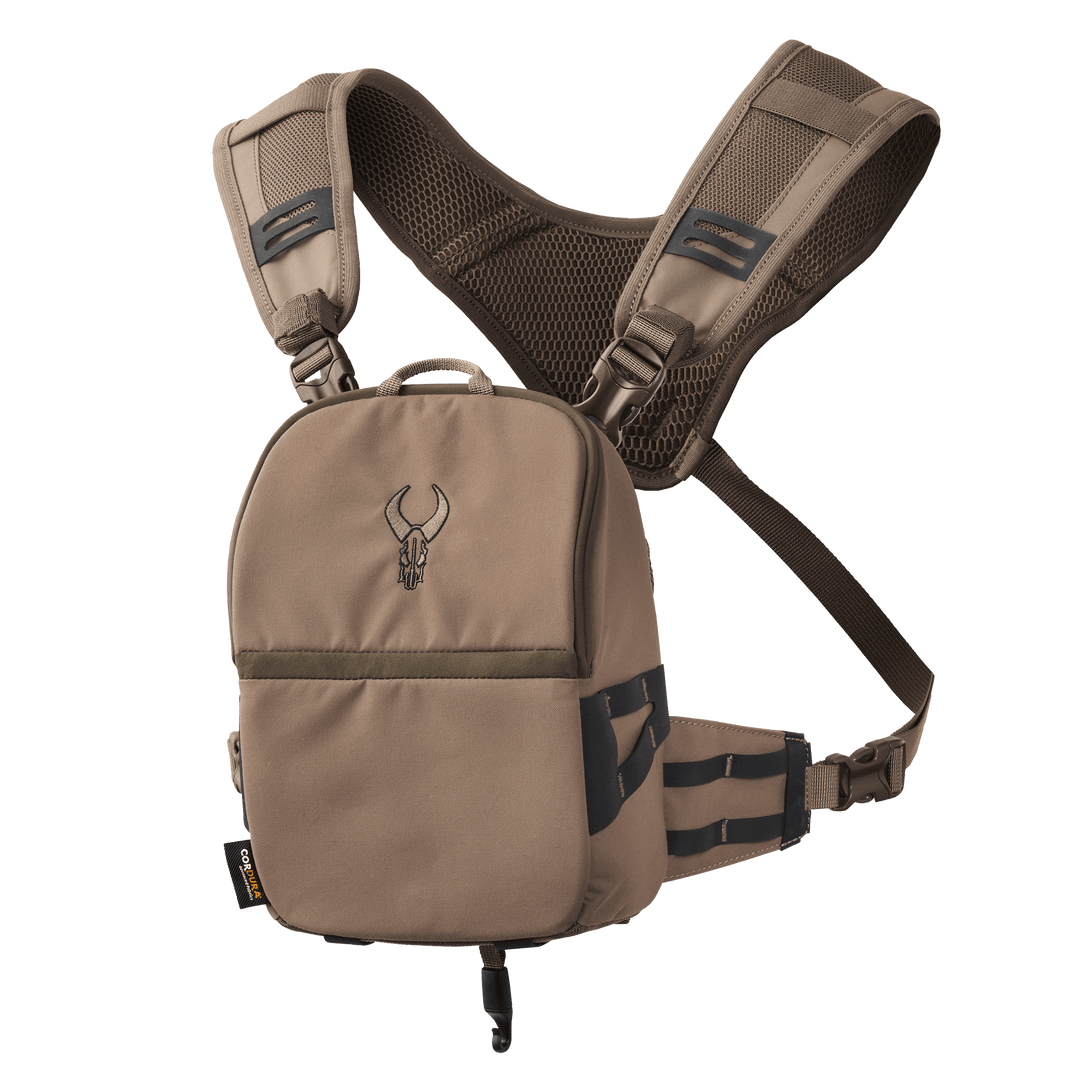 Tan Badlands chest pack with mesh straps and embroidered skull logo, designed for hands-free outdoor gear storage.