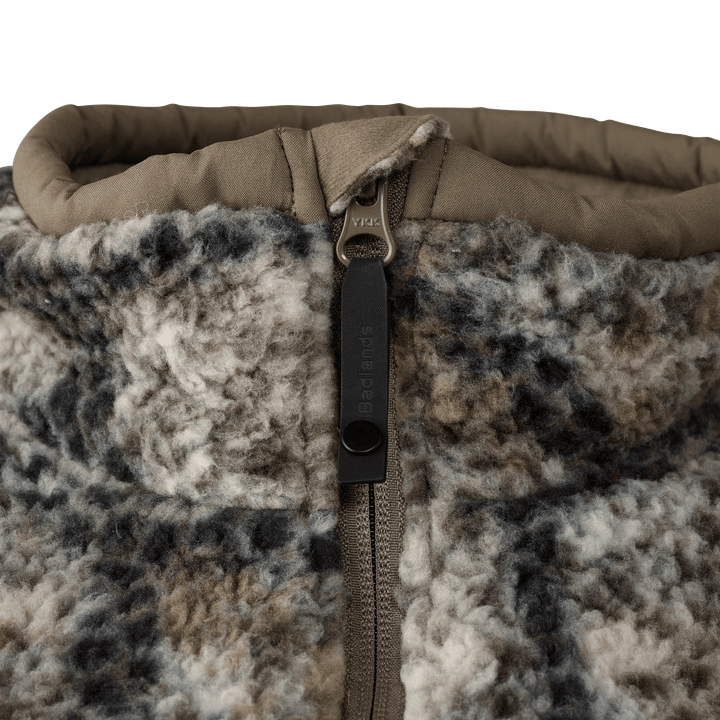 Close-up of Badlands fleece jacket collar and zipper, featuring the Badlands skull logo on the zipper pull.