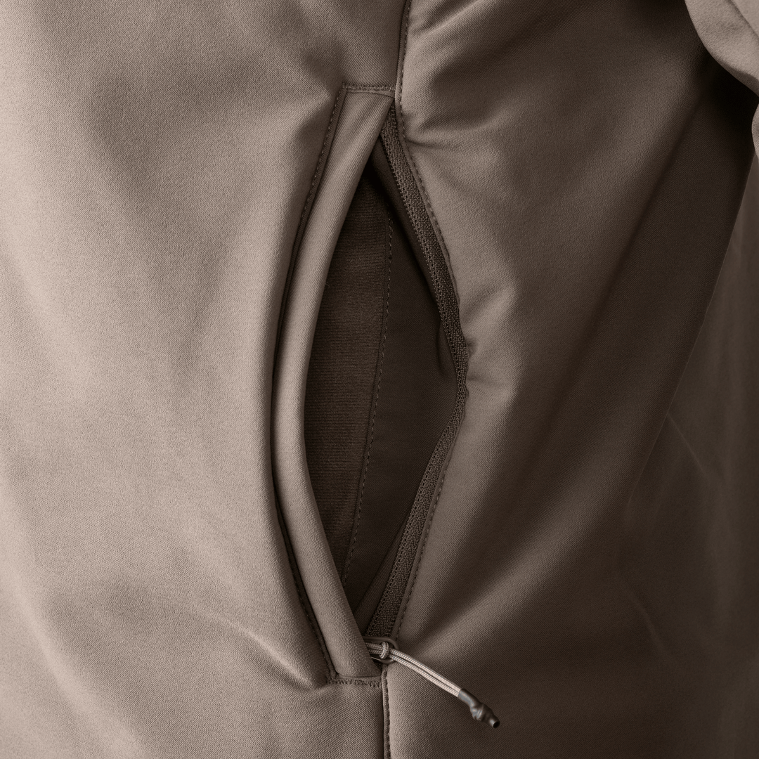 Close-up of a Badlands jacket pocket with zipper pull, showing durable fabric and stitching.