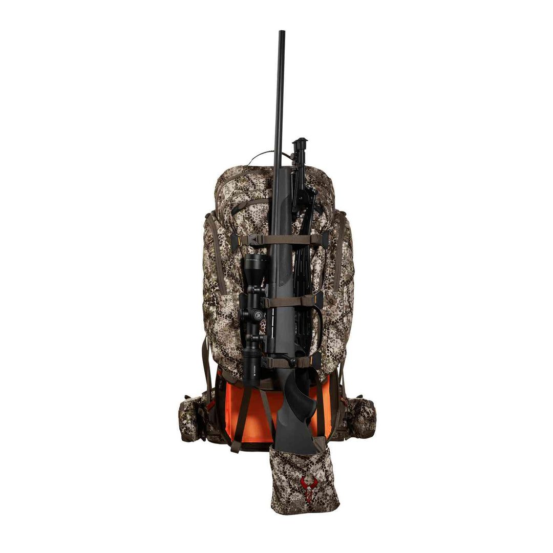 Badlands camo hunting backpack with rifle holder and skull logo, shown from the back with orange safety panel visible.