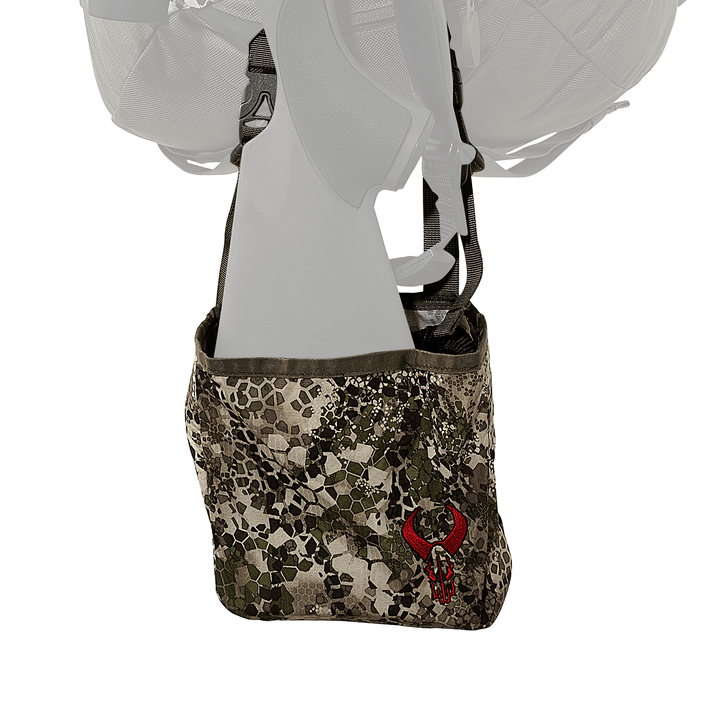 Camouflage Badlands pouch with red skull logo, attached to a backpack; designed for outdoor gear storage.
