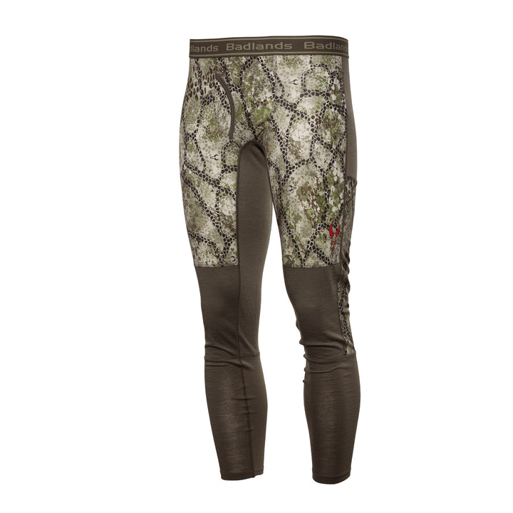 Badlands camo base layer pants with logo skull on thigh, elastic waistband, and earth-tone pattern for outdoor use.