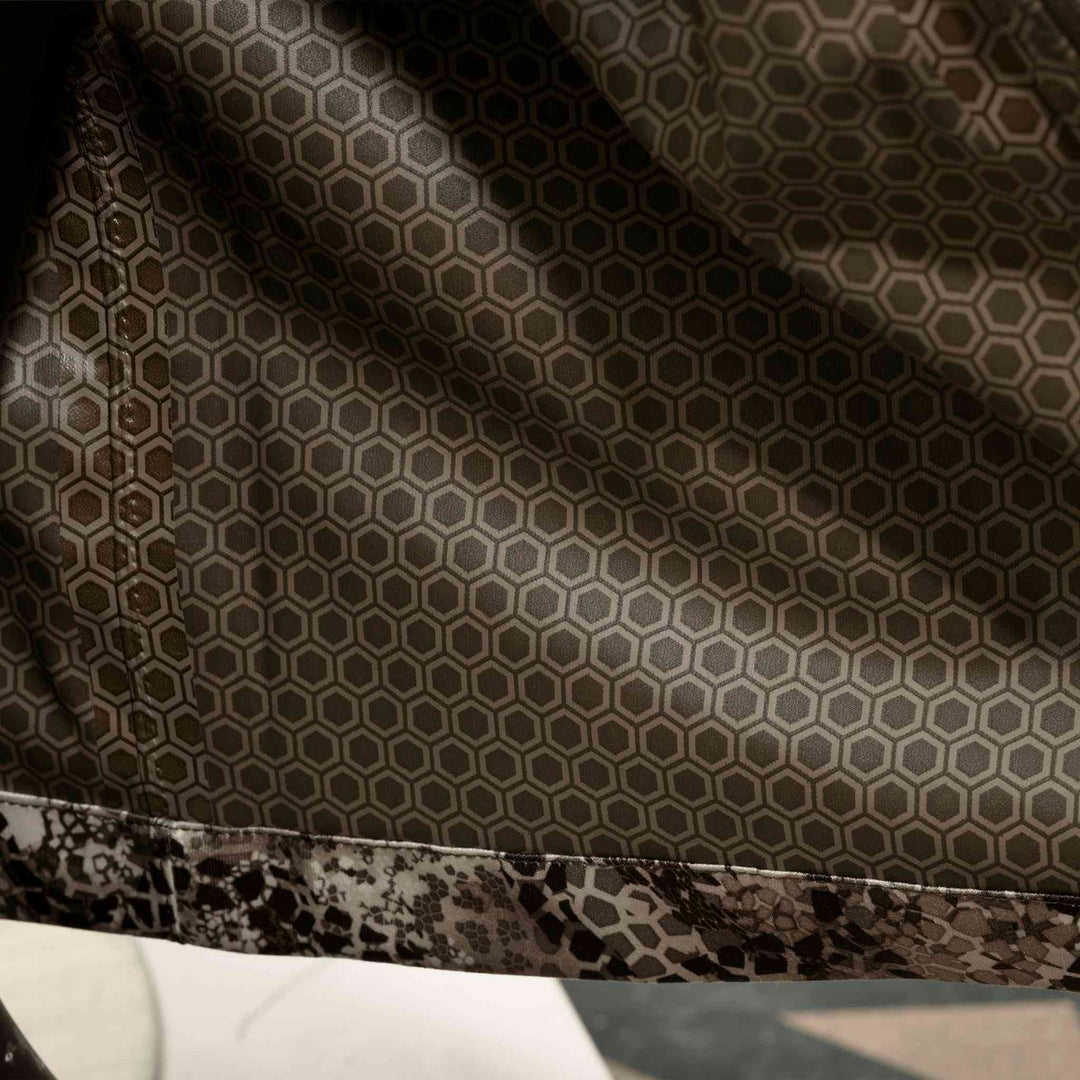 Close-up of Badlands fabric with hexagonal pattern and camo trim; subtle Badlands skull logo is integrated in the design.