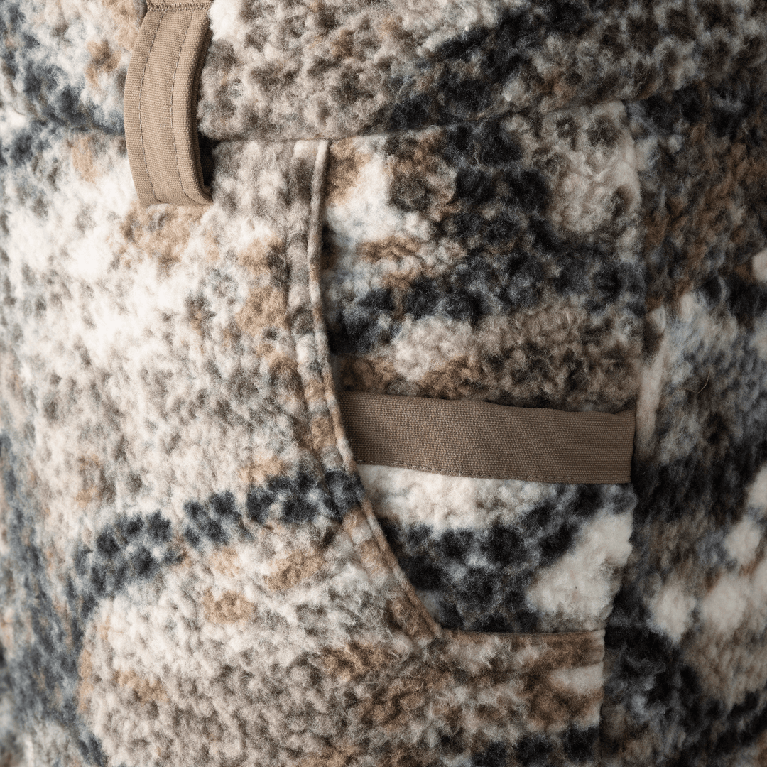Close-up of a Badlands fleece jacket pocket in camo pattern, showing soft texture and reinforced trim.