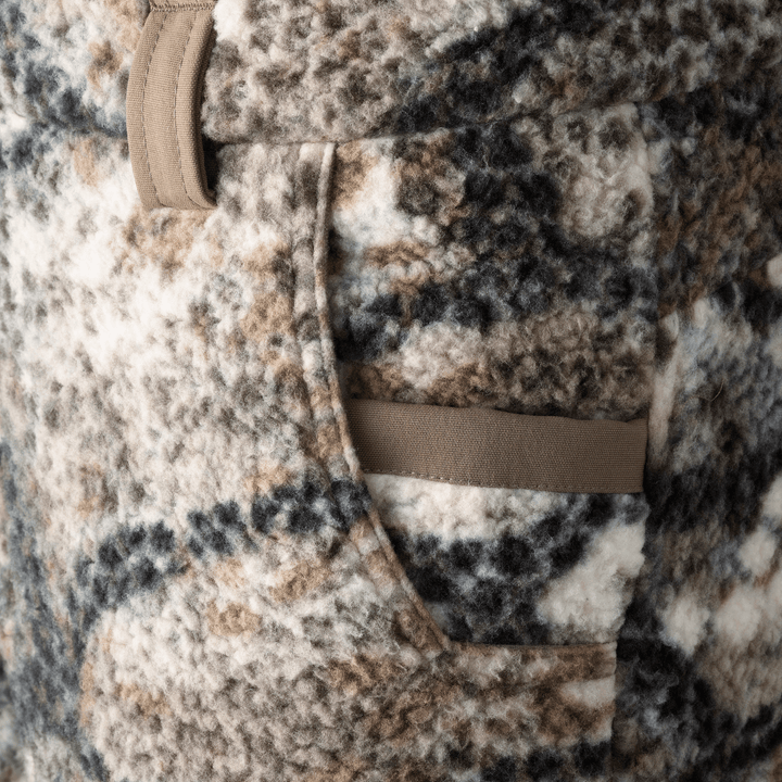 Close-up of a Badlands fleece jacket pocket in camo pattern, showing soft texture and reinforced trim.