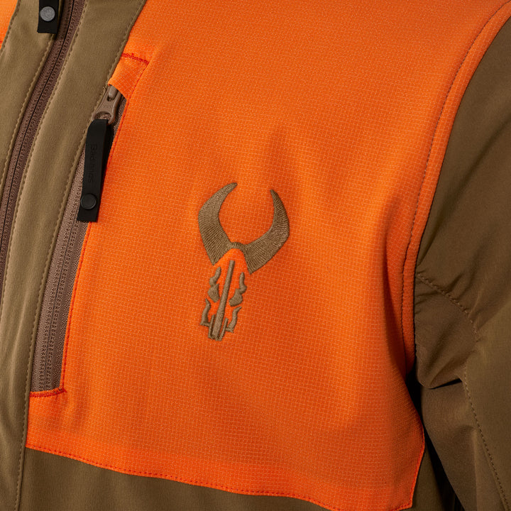 Close-up of a Badlands jacket in orange and brown, featuring the embroidered Badlands skull logo on the chest.
