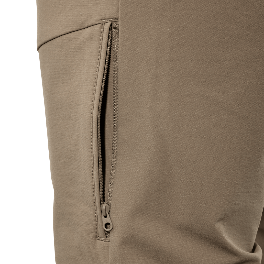 Close-up of tan Badlands pants showing a zippered side pocket for secure storage.