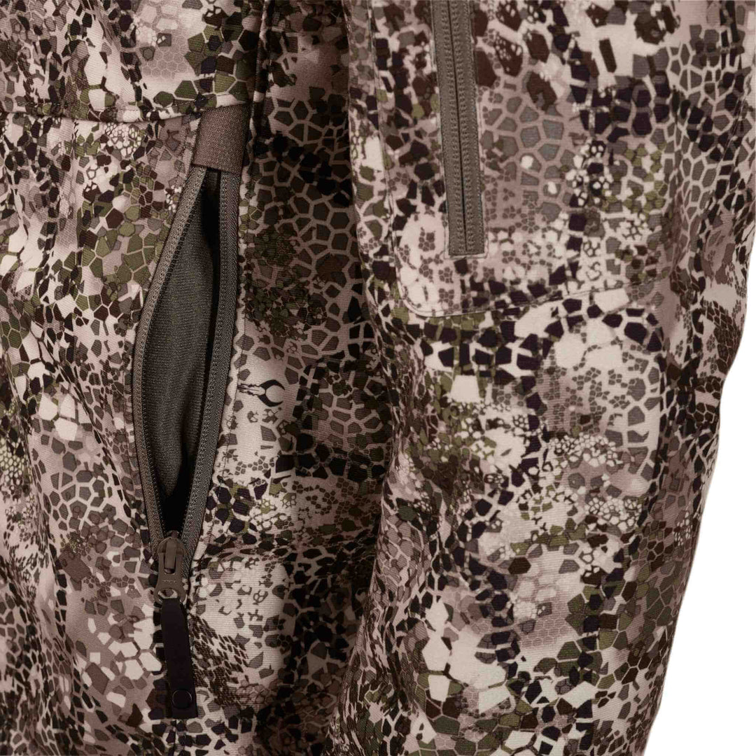 Close-up of Badlands camo fabric with zippered pocket and subtle Badlands skull logo on the pattern.