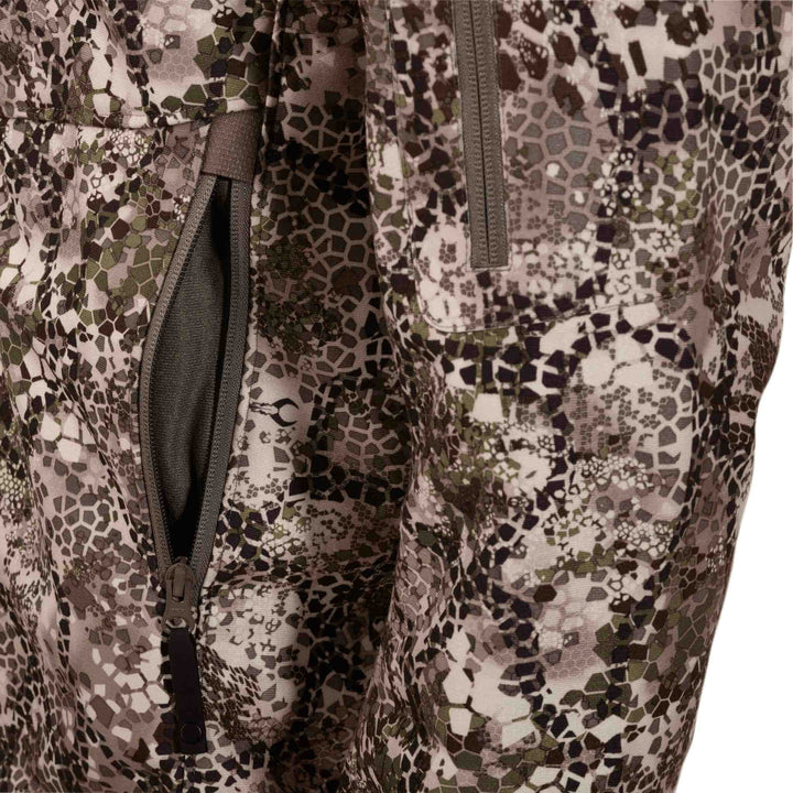 Close-up of Badlands camo fabric with zippered pocket and subtle Badlands skull logo on the pattern.