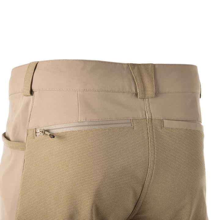 Back view of tan Badlands pants with textured fabric, zippered pocket, and reinforced belt loops.