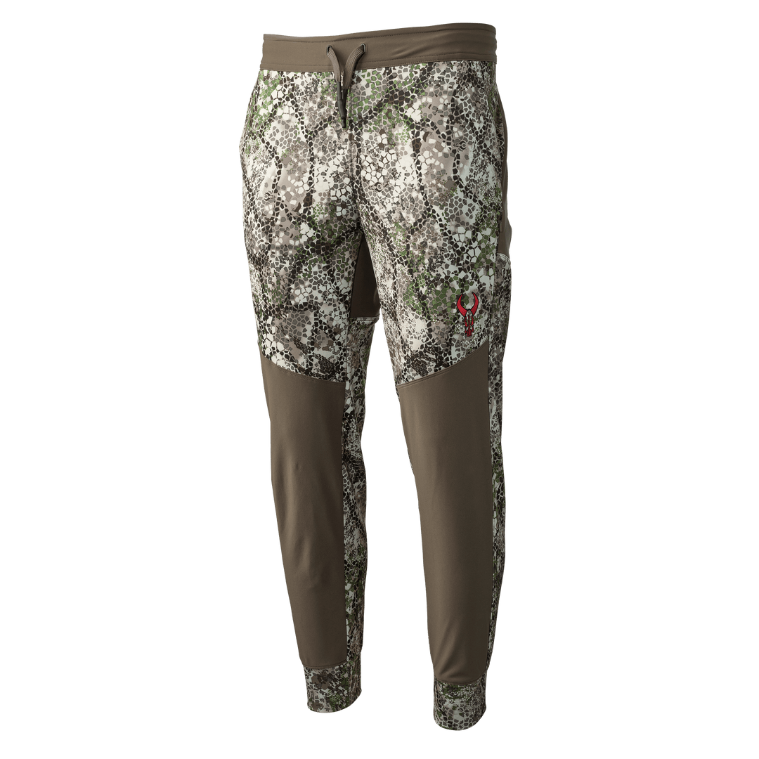 Badlands camo pants with brown panels and red skull logo on thigh, designed for outdoor and hunting activities.