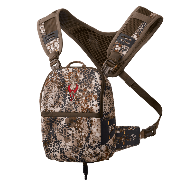 Badlands camo chest pack with red skull logo, adjustable straps, and mesh back panel for outdoor gear organization.