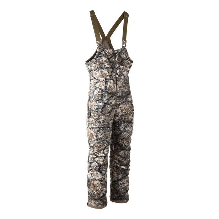 Badlands camo hunting bib with adjustable straps, front zipper, and logo skull patch; designed for outdoor use.