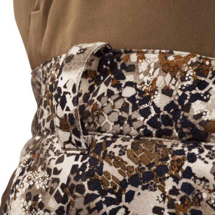 Close-up of Badlands camo fabric with belt loop, showing hexagonal pattern in brown, tan, and black.