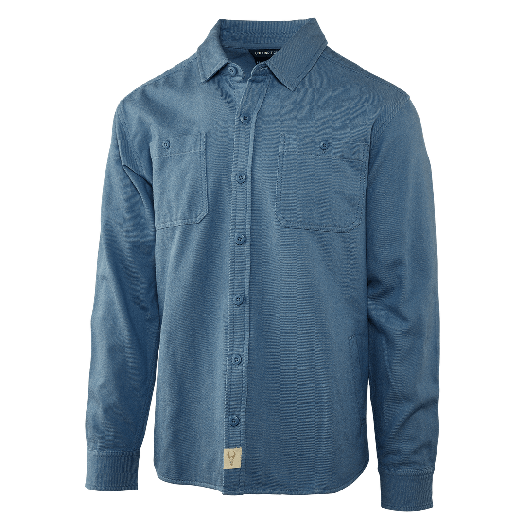Blue Badlands long-sleeve shirt with two chest pockets and skull logo tag at hem, front view.