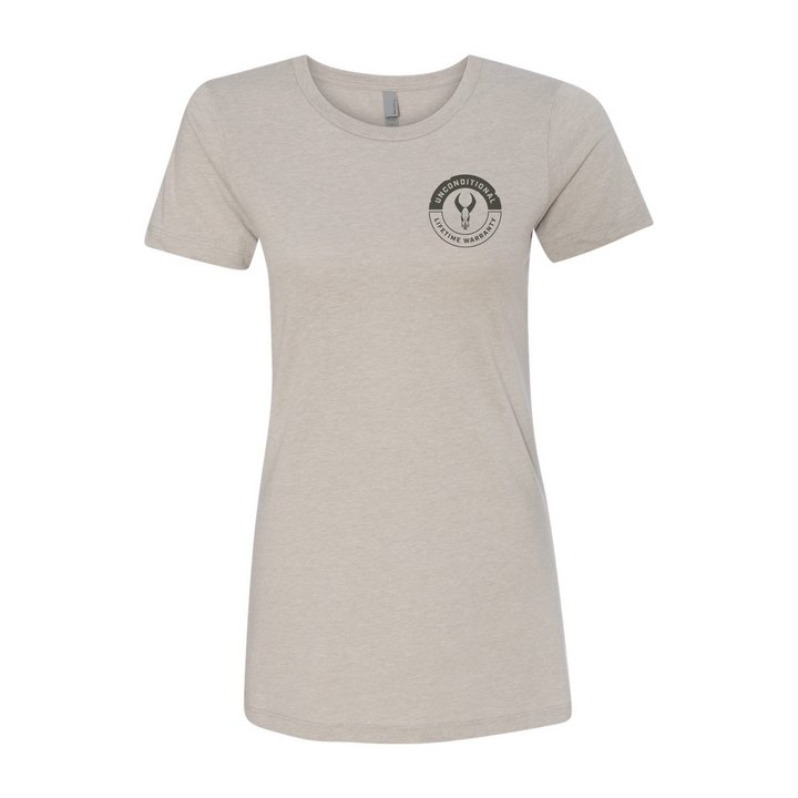 Light tan women's t-shirt with Badlands skull logo and "Unconditional Lifetime Warranty" text on left chest.