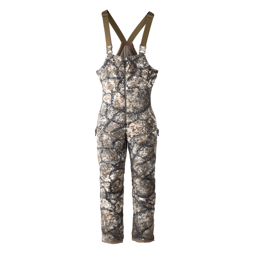 Badlands camo hunting bib with front zipper and logo skull on chest; adjustable straps for comfort and fit.