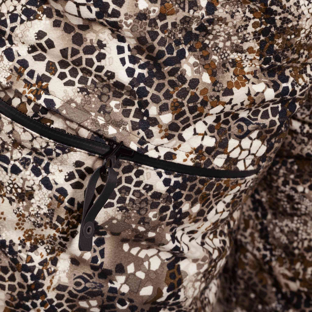 Close-up of Badlands camo fabric with a zipper and subtle Badlands skull logo in the pattern.