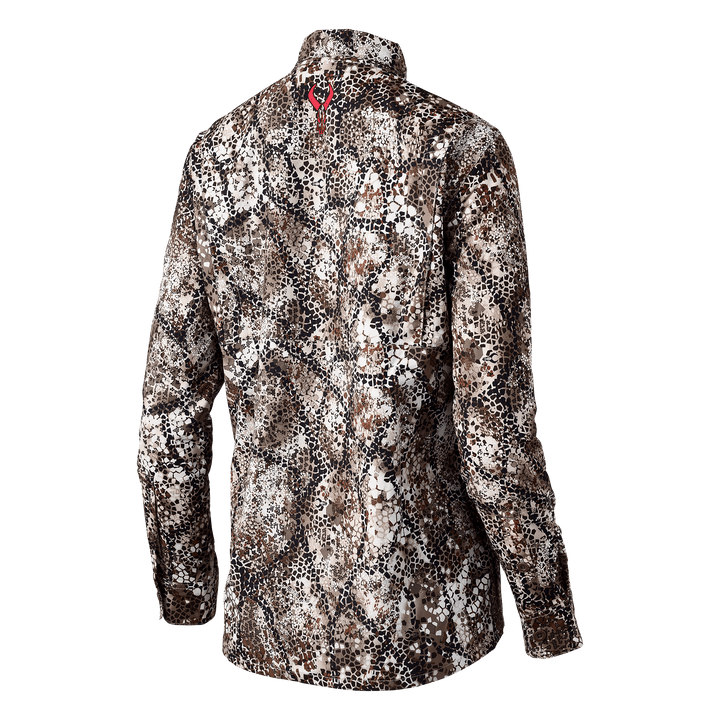Back view of a Badlands camo shirt with red skull logo at the neck; long sleeves, earth-tone pattern.