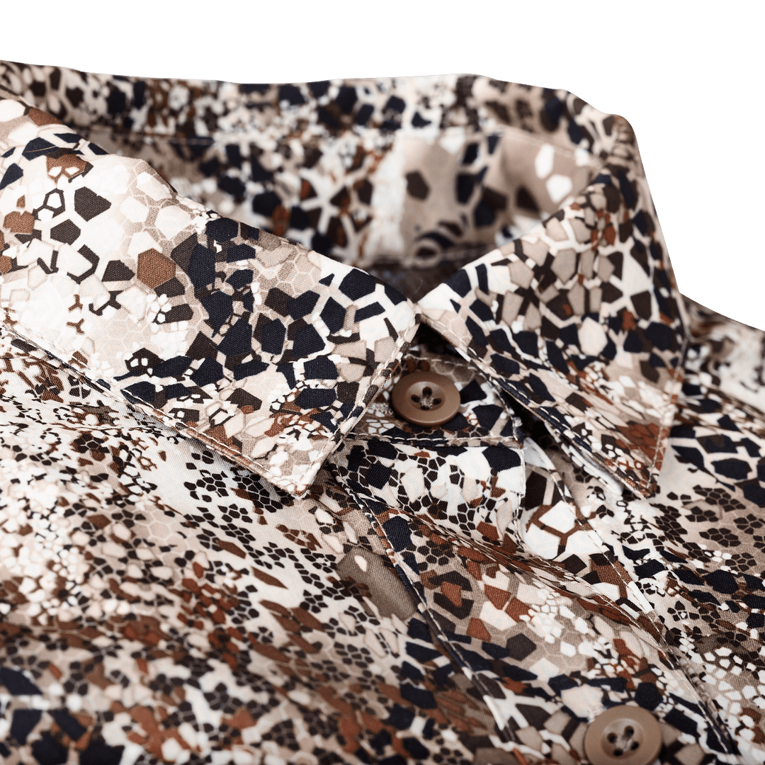 Close-up of a Badlands camo shirt collar with brown buttons and subtle Badlands skull logo in the pattern.