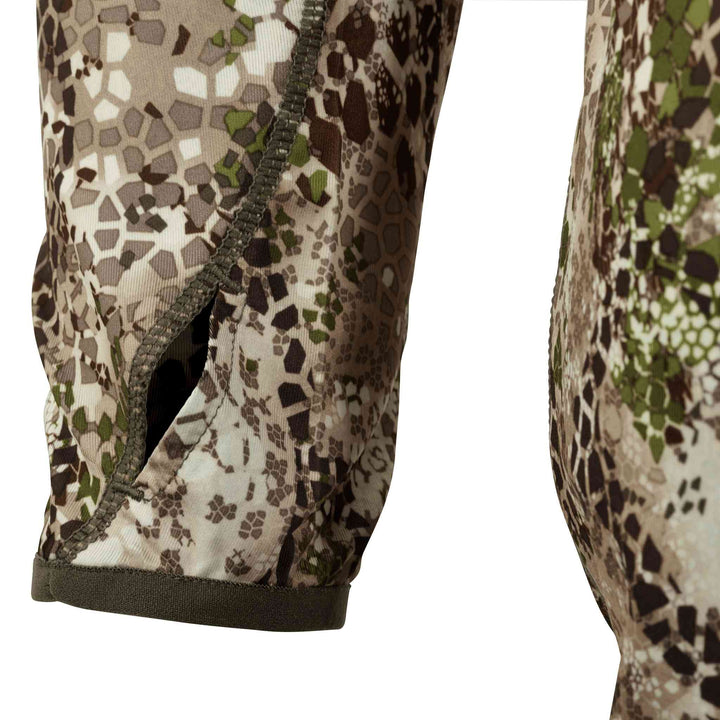 Close-up of Badlands camo sleeve with thumbhole; features hexagonal pattern and subtle Badlands skull logo.